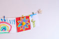 Load image into Gallery viewer, Wall mounted personalised wooden star art hanger displaying vibrant kids artwork