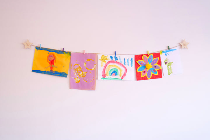 Laser engraved children's artwork display hanging colourful pictures on a wall