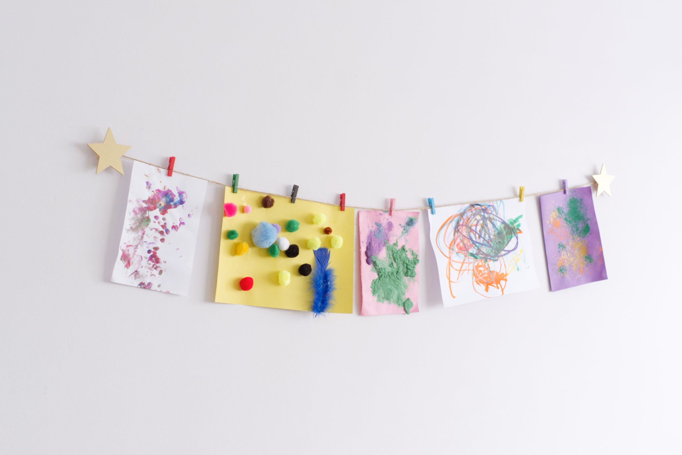 Gold star design art hanger displaying kids crafts on a wall