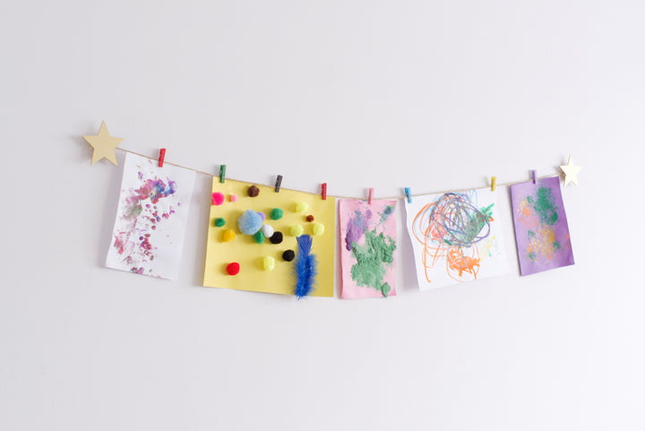 Gold star design art hanger displaying kids crafts on a wall